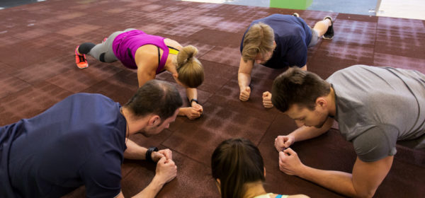fitness, sport, exercising, training and healthy lifestyle concept - group of people doing plank exercise in gym